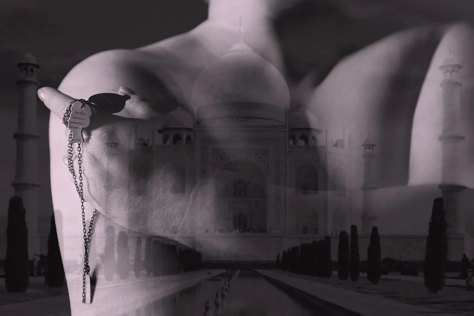 Distant monument — Photo: Norbert Banhalmi A shoulder and a hand in the foreground, a domed monument at the end of a long avenue behind.