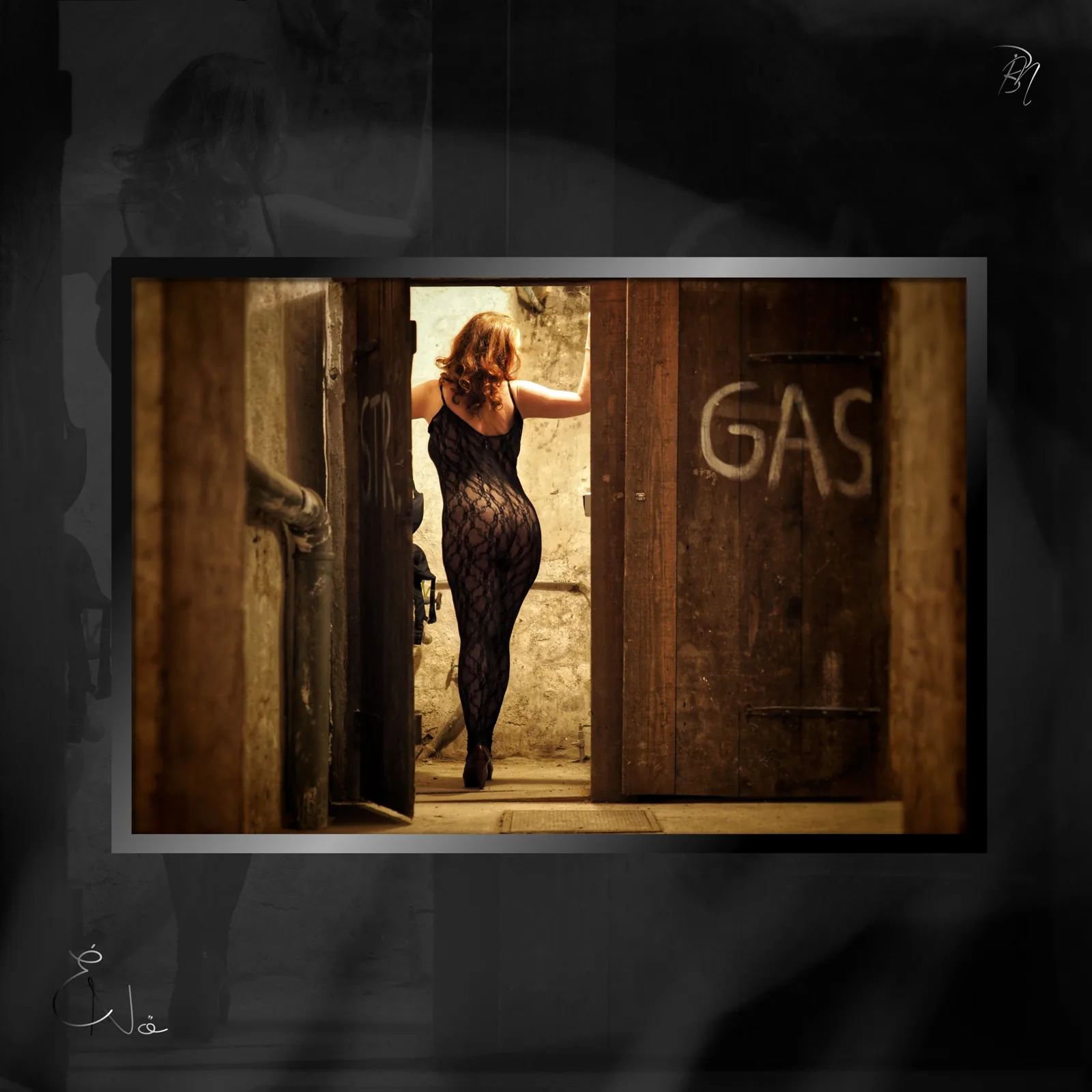 In the barn door — Photo: Norbert Banhalmi A woman in a lace dress stands in an old wooden doorway marked GAS.