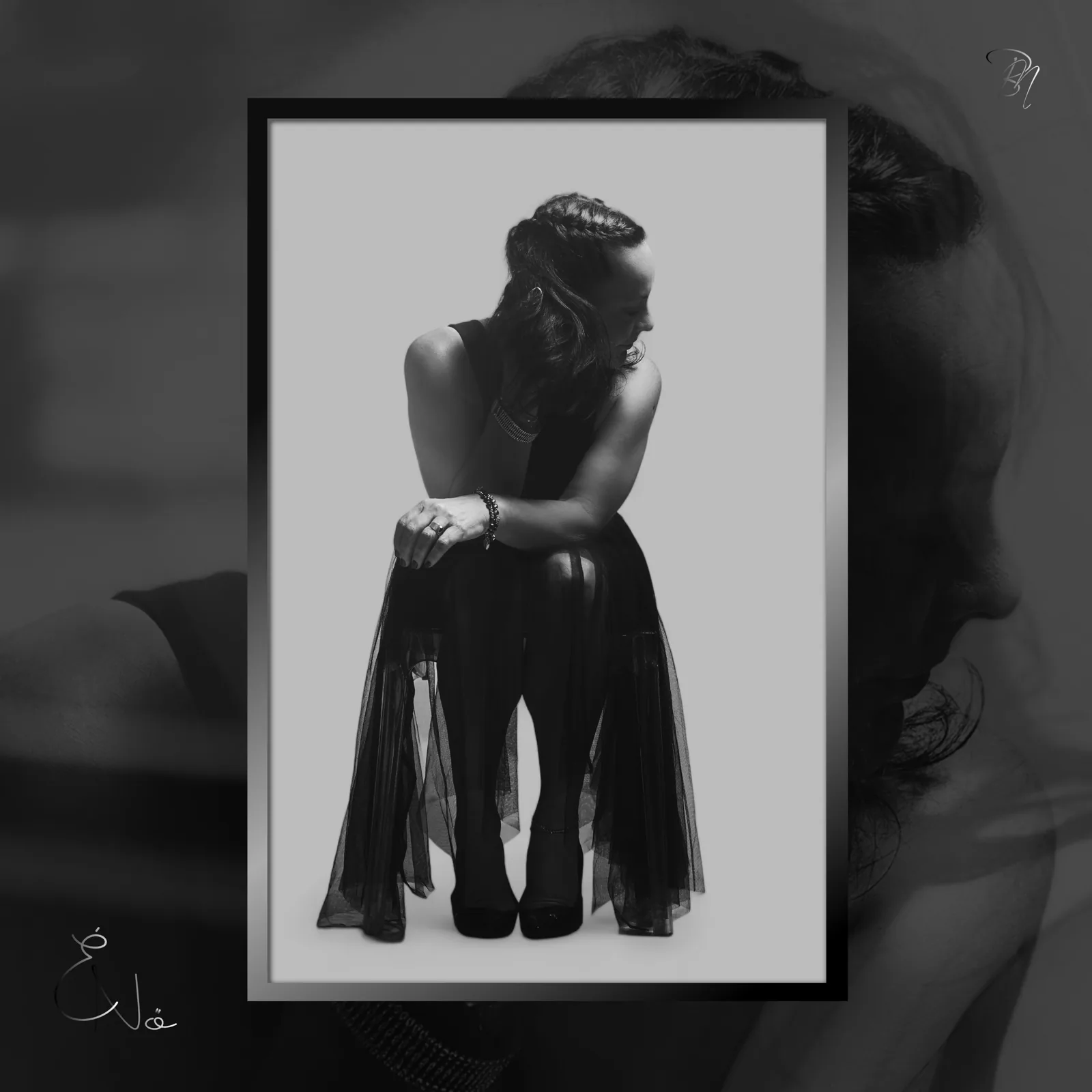 Tulle — Photo: Norbert Banhalmi Black and white: a woman sits with her arms around her knees in a tulle skirt.