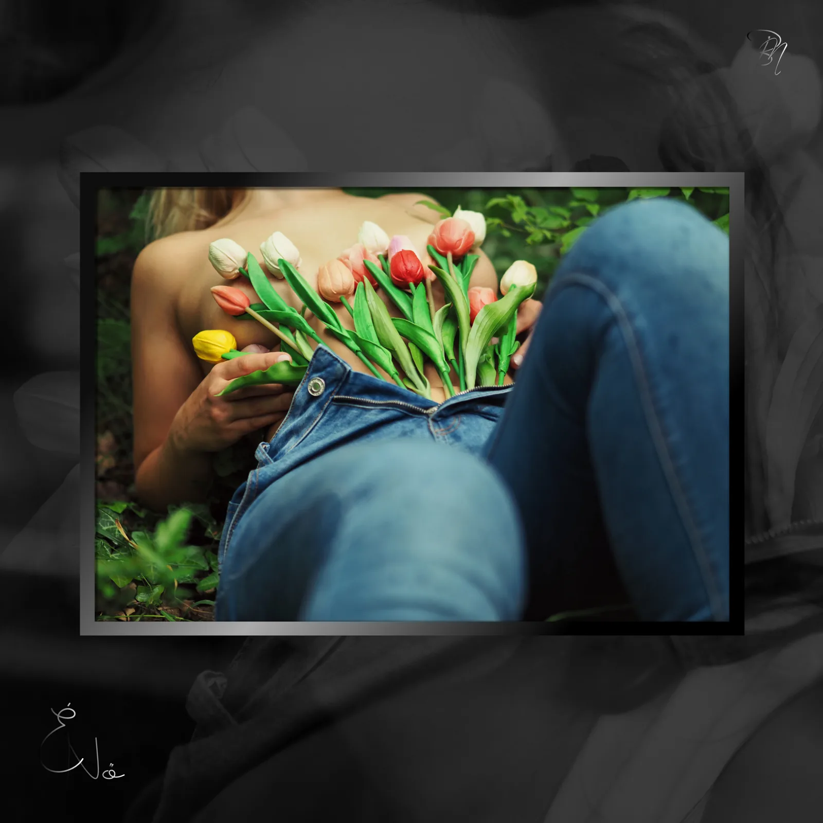 Tulips in the lap — Photo: Norbert Banhalmi A bunch of tulips rests in a woman's lap as she sits in jeans in the grass.