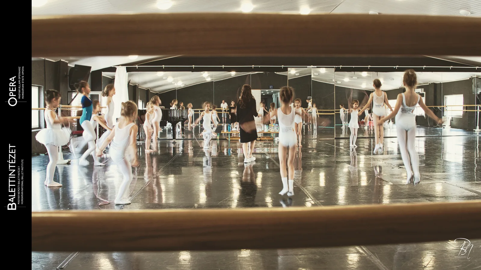 Full studio — Photo: Norbert Banhalmi A wide view of a rehearsal room with students working at the barre and in the mirrors.